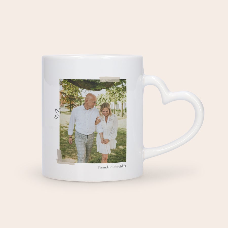 Foto krus - Hjerte Hvit krus med hjerteformet håndtak, trykt med bilde av et par og teksten Fremdeles forelsket.