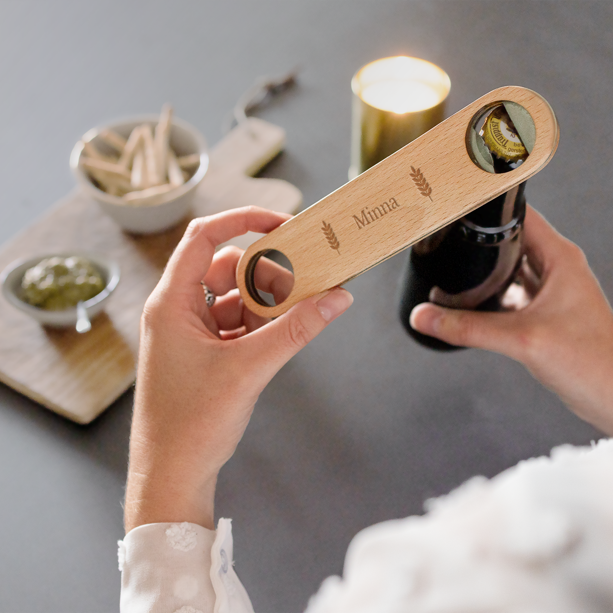 Puinen pullonavaaja kaiverruksella