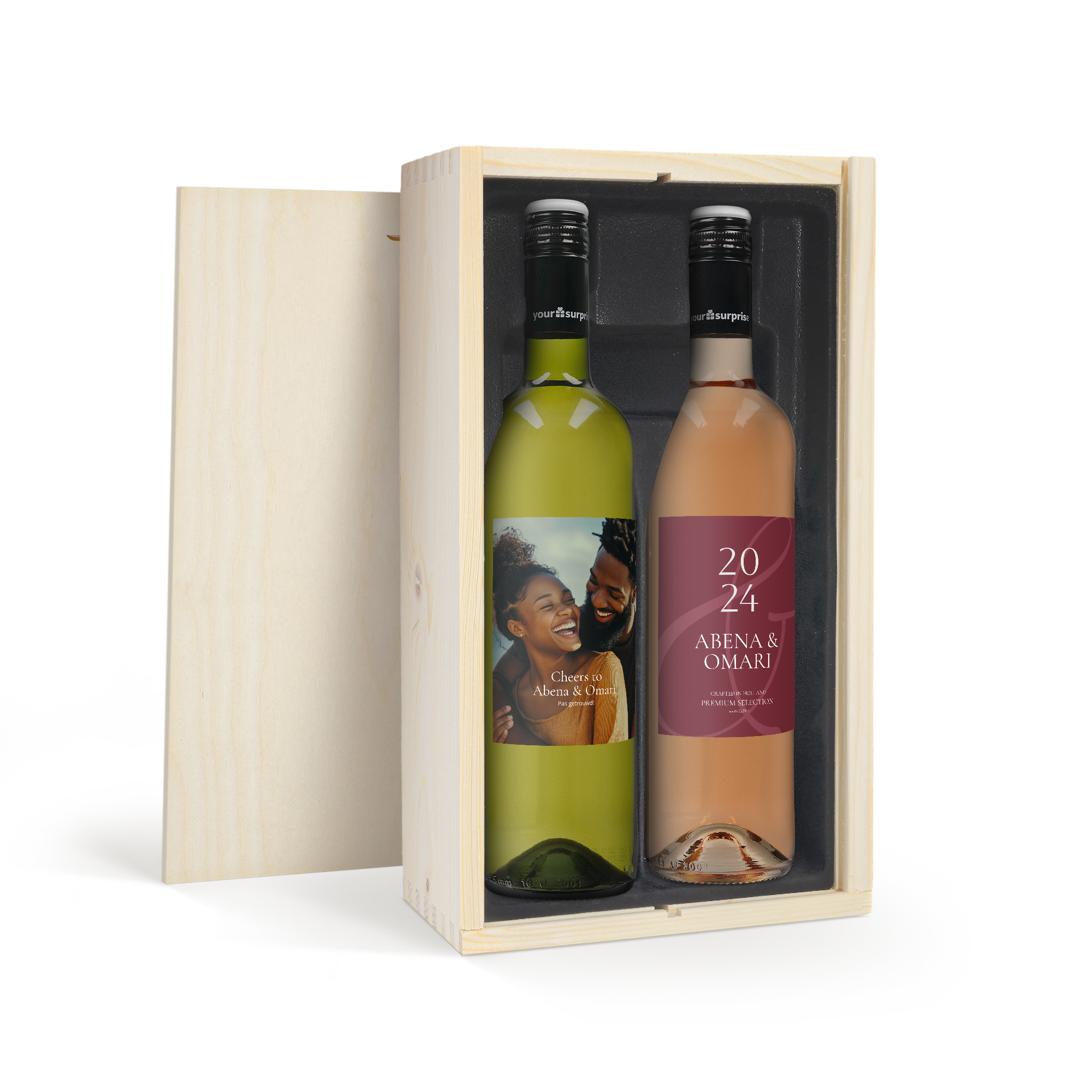 Caja de madera con dos botellas de vino Luc Pirlet y etiqueta personalizada. La botella verde tiene una foto de pareja y "Cheers to Abena & Omari", la rosada "2024 Abena & Omari".