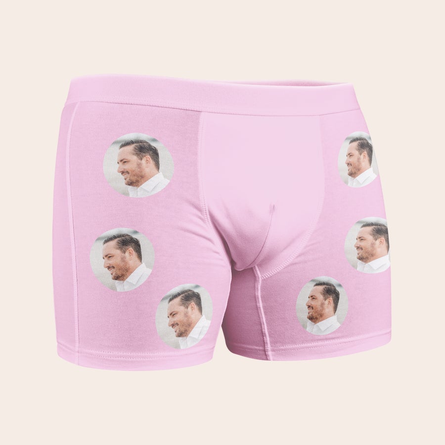 Boxer med bilde Rosa boksershorts med bilde, trykt med flere gjentatte sirkulære bilder av et mannsansikt i profil.