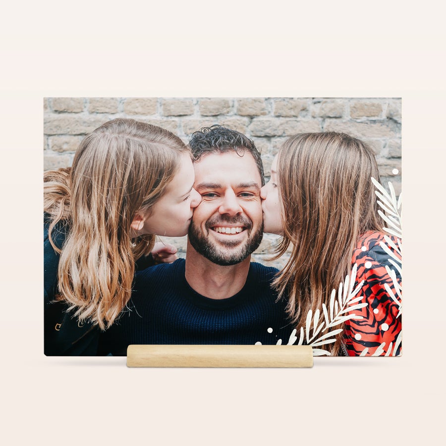 Tarjeta de Navidad con foto Una tarjeta de madera para enviar tu mensaje de Navidad, impresa con la foto personalizada de un padre y dos hijas besándole la mejilla.