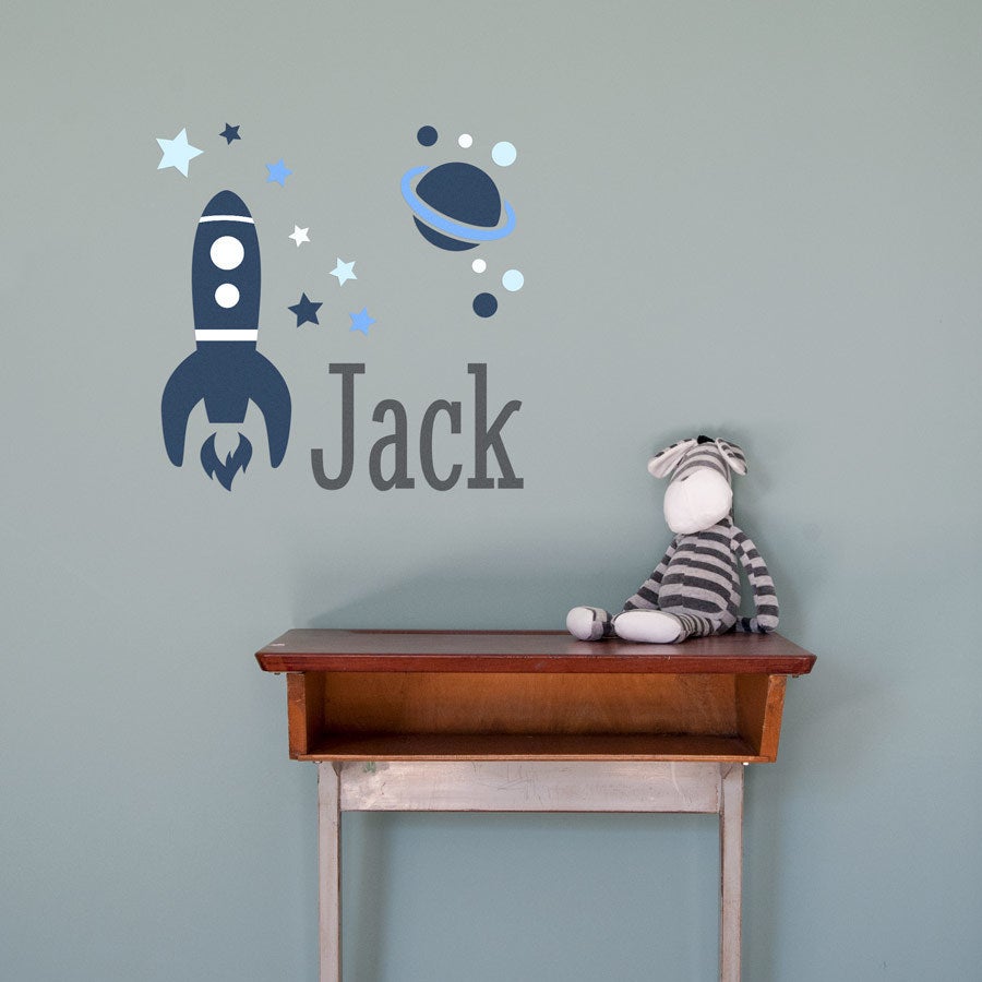 Unik väggdekal med namn Jack och rymdmotiv för barnens sovrum, tryckt i mörkblått och ljusblått.