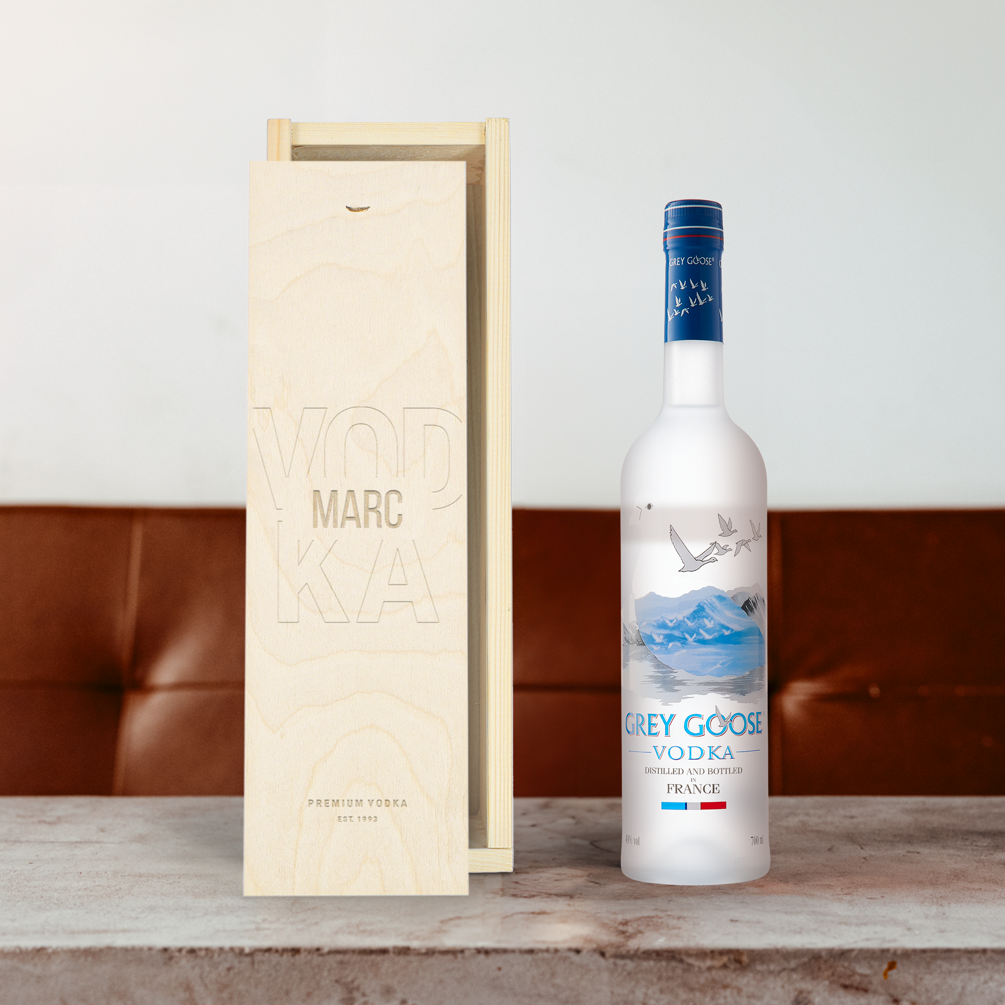 Grey Goose vodka bottle next to an engraved wooden case with the text Vodka Marc
