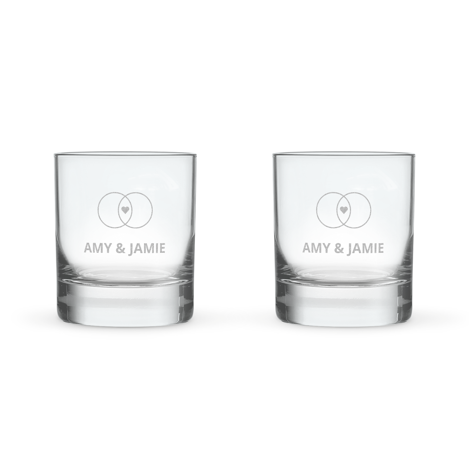 Pair of personalized whisky glasses engraved with names Amy & Jamie and two interlocking rings, one with a heart.