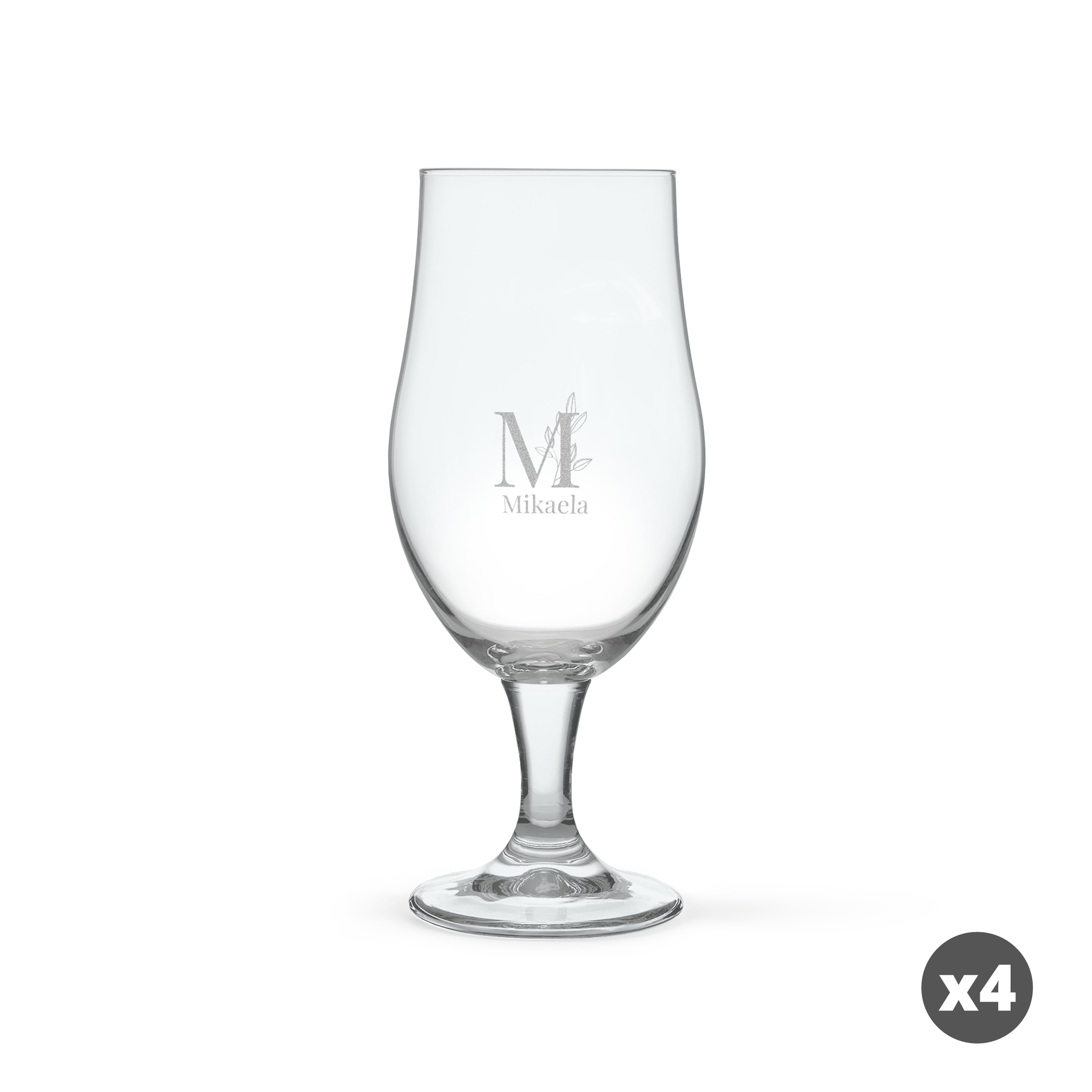 Ett roligt ölglas, graverat med ett stort M med lövverk och namnet Mikaela. Glaset är mörkblått.