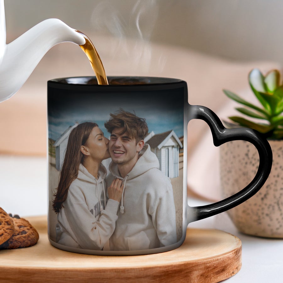 Caneca personalizada - Caneca mágica Caneca mágica preta personalizada com foto de um casal e pega em forma de coração. Ofereça uma caneca mágica.