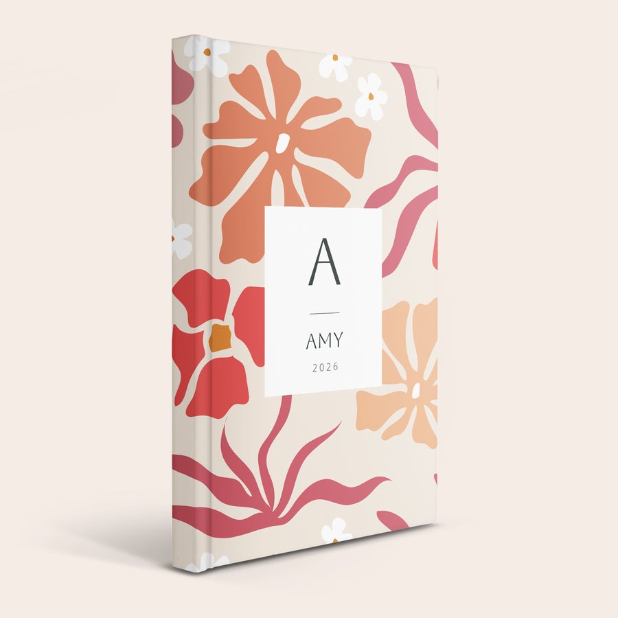 Agenda personalizada Agenda personalizada 2026 con estampado floral, impresa con inicial A, nombre AMY y año.