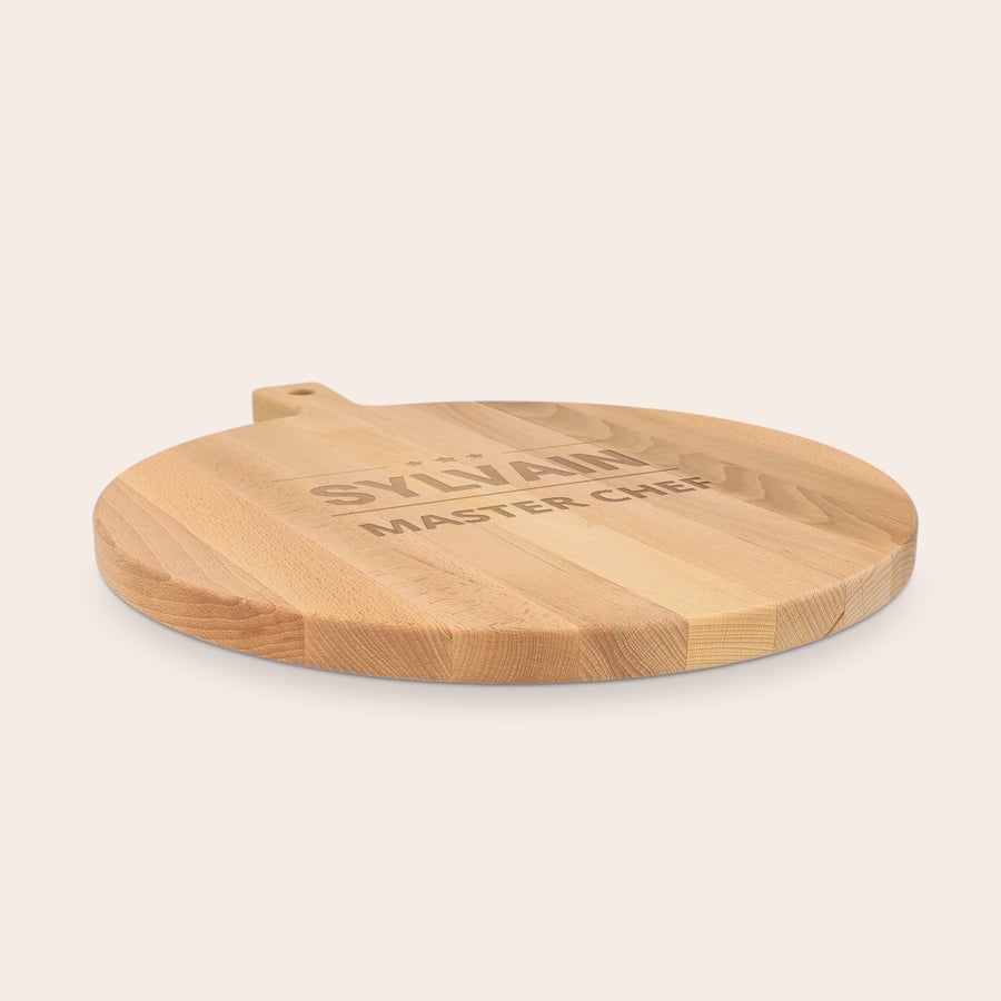 Une planche à pizza personnalisée - en hêtre - ronde - avec gravure Planche à pizza personnalisée en bois clair gravée avec le prénom Sylvain et le texte Master Chef