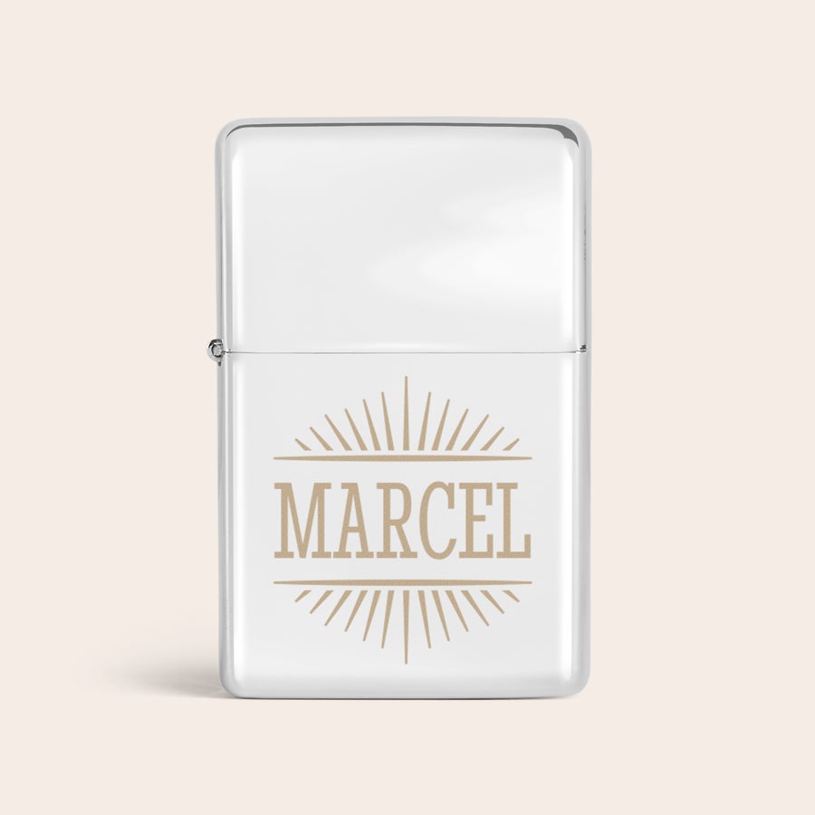 Aansteker graveren Zilveren aansteker gegraveerd met de naam Marcel en een zonnestraalmotief.