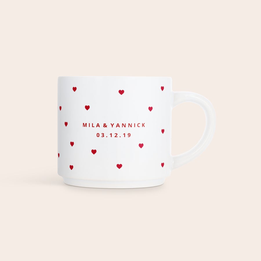 Stapelbare tassen mit Foto Eine weiße, stapelbare Fototasse mit roten Herzen, bedruckt mit den Namen Mila & Yannick und dem Datum 03.12.19.