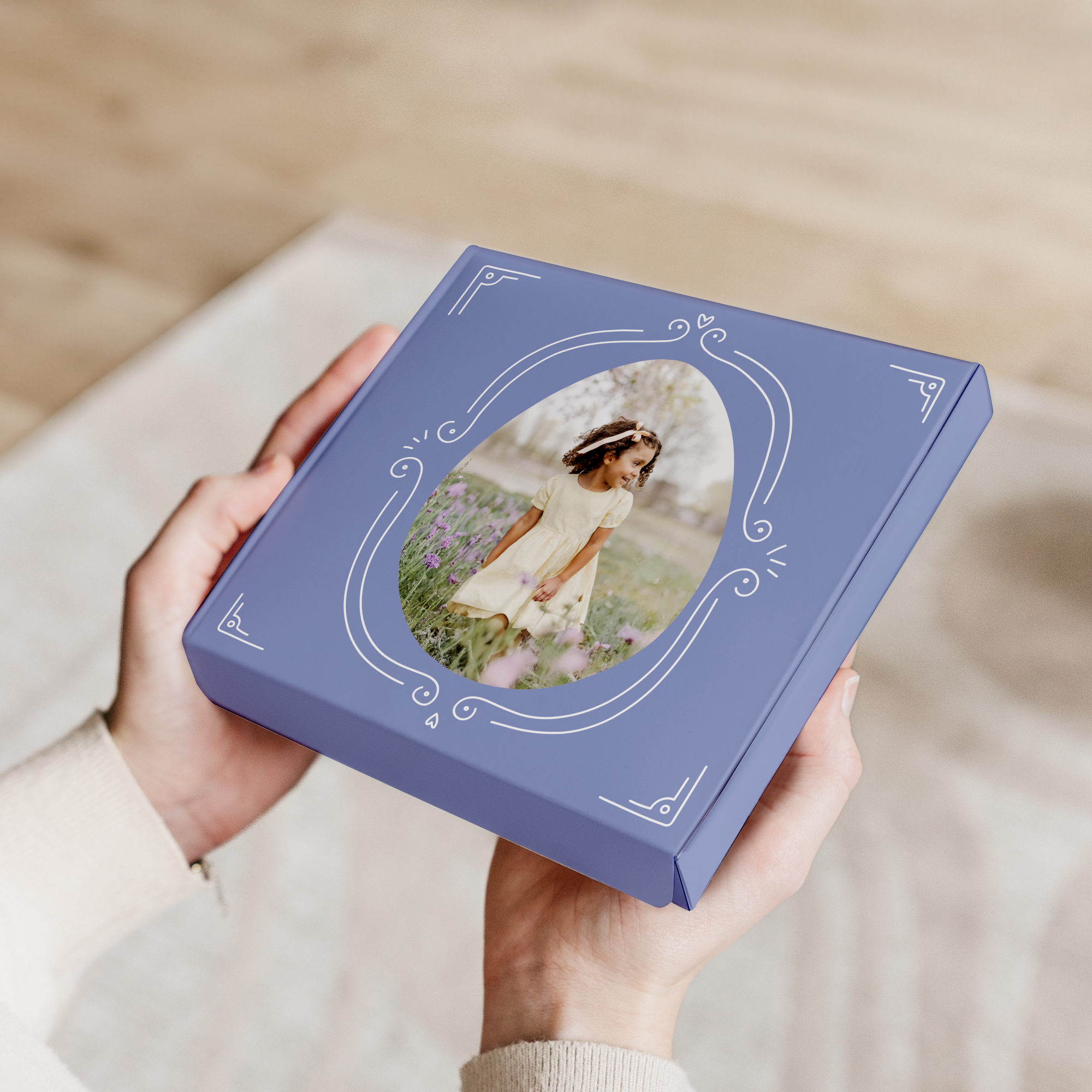 Cutie cadou personalizată Milka de Paște cu design imprimat, o fotografie cu o fetiță într-un cadru oval și ornamente de Paște, ținută în mâini.