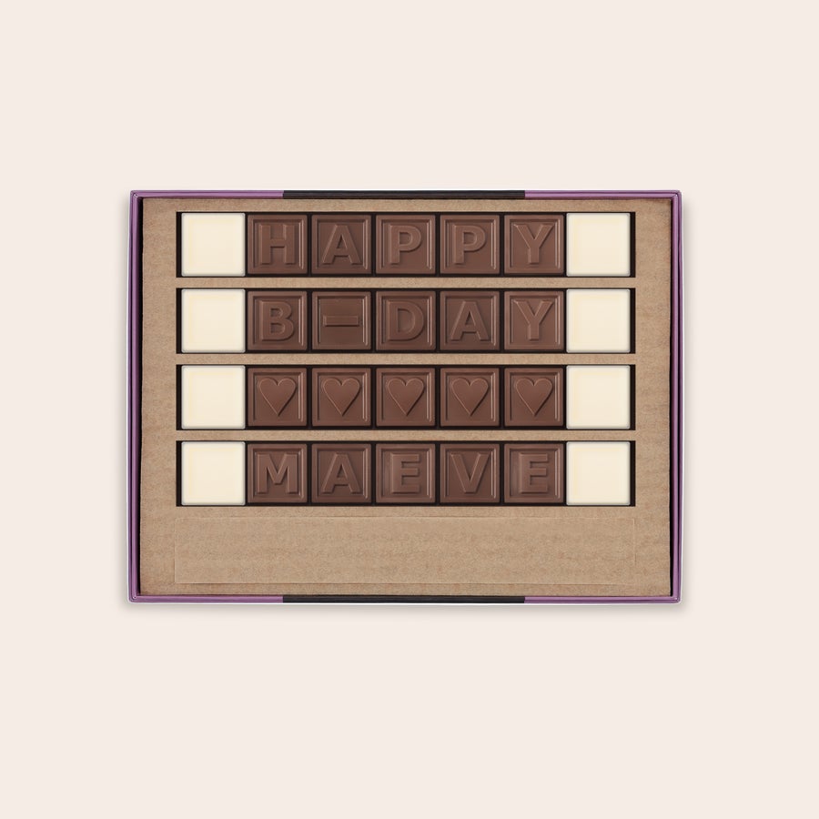 Chocotelegrama personalizado Caja abierta con mensaje de chocolate personalizado "HAPPY B-DAY MAEVE" con corazones, impreso en chocolate con leche y blanco.