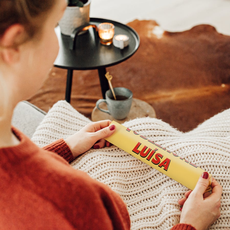 Toblerone Mulher segura barra de chocolate Toblerone personalizada com o nome LUÍSA impresso. Uma barra de chocolate Toblerone personalizada diz mais de mil palavras.