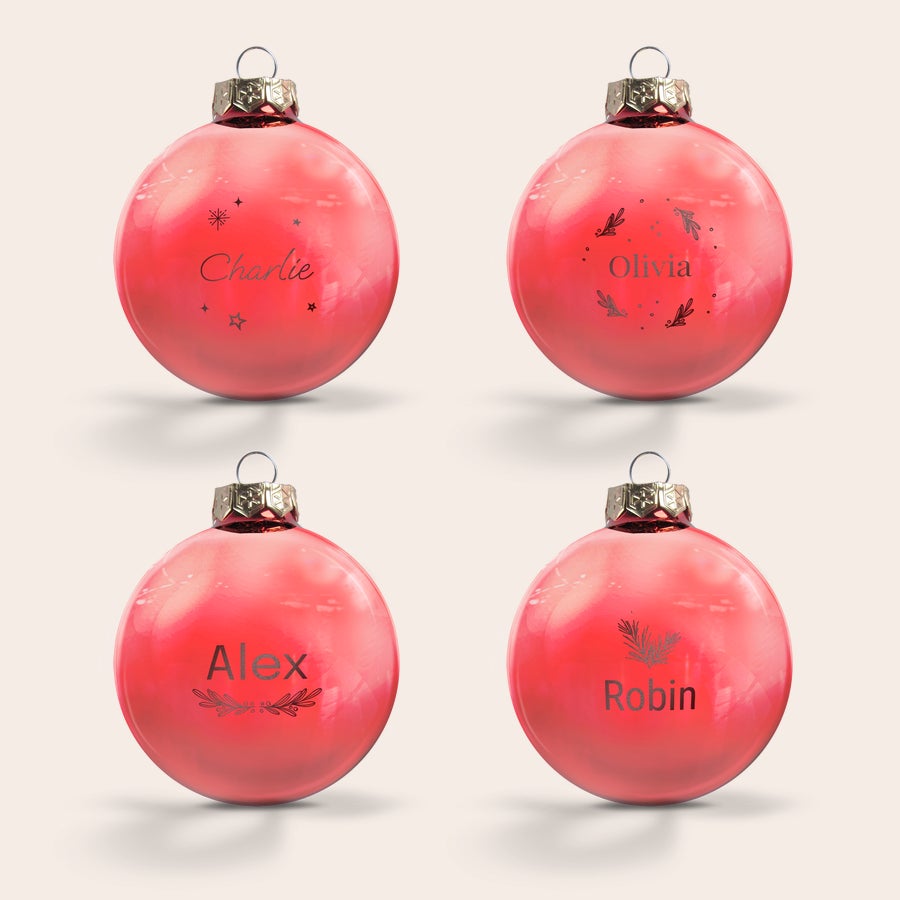 Glass bauble with name Four red glass Christmas baubles, each engraved with a different personalized name like Charlie, Olivia, Alex, and Robin, adding a unique touch to your Christmas tree.