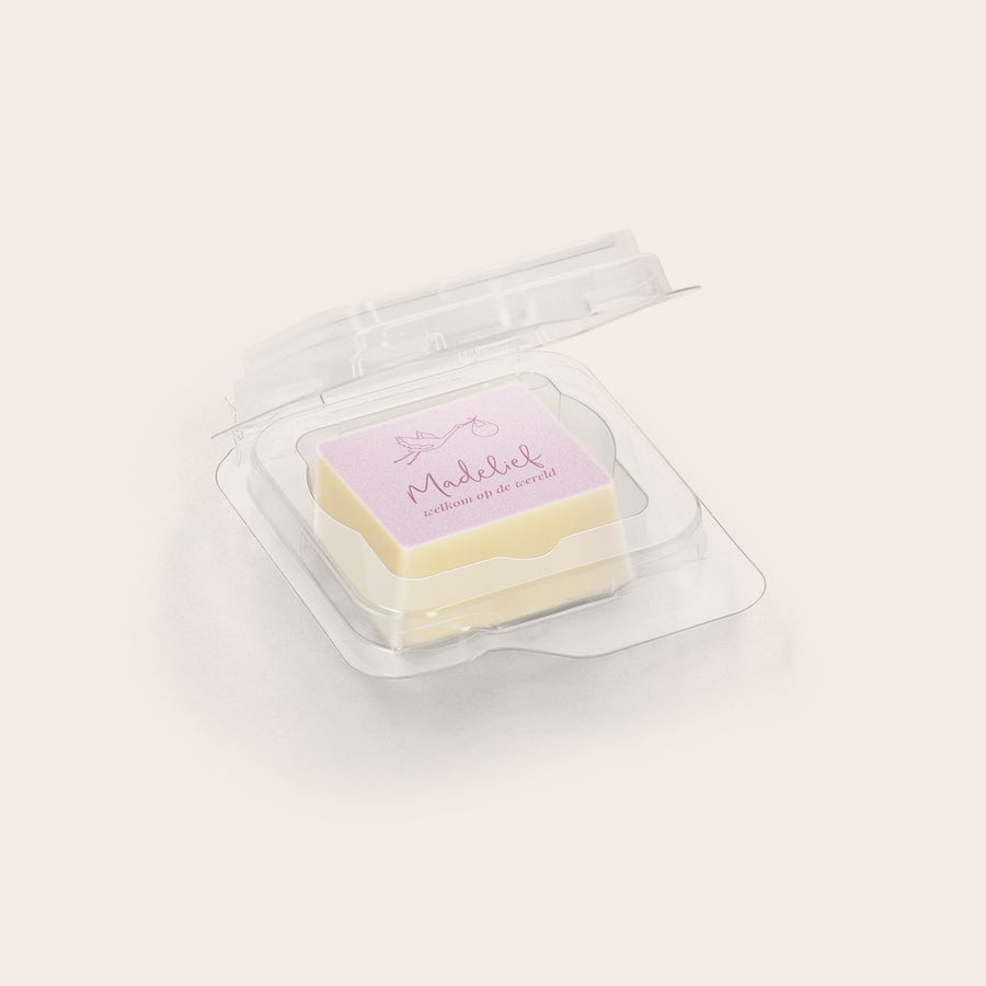 Chocolade traktatie met foto Witte fotopraline met de tekst Madelief welkom op de wereld bedrukt met een foto van een ooievaar in een open blisterverpakking