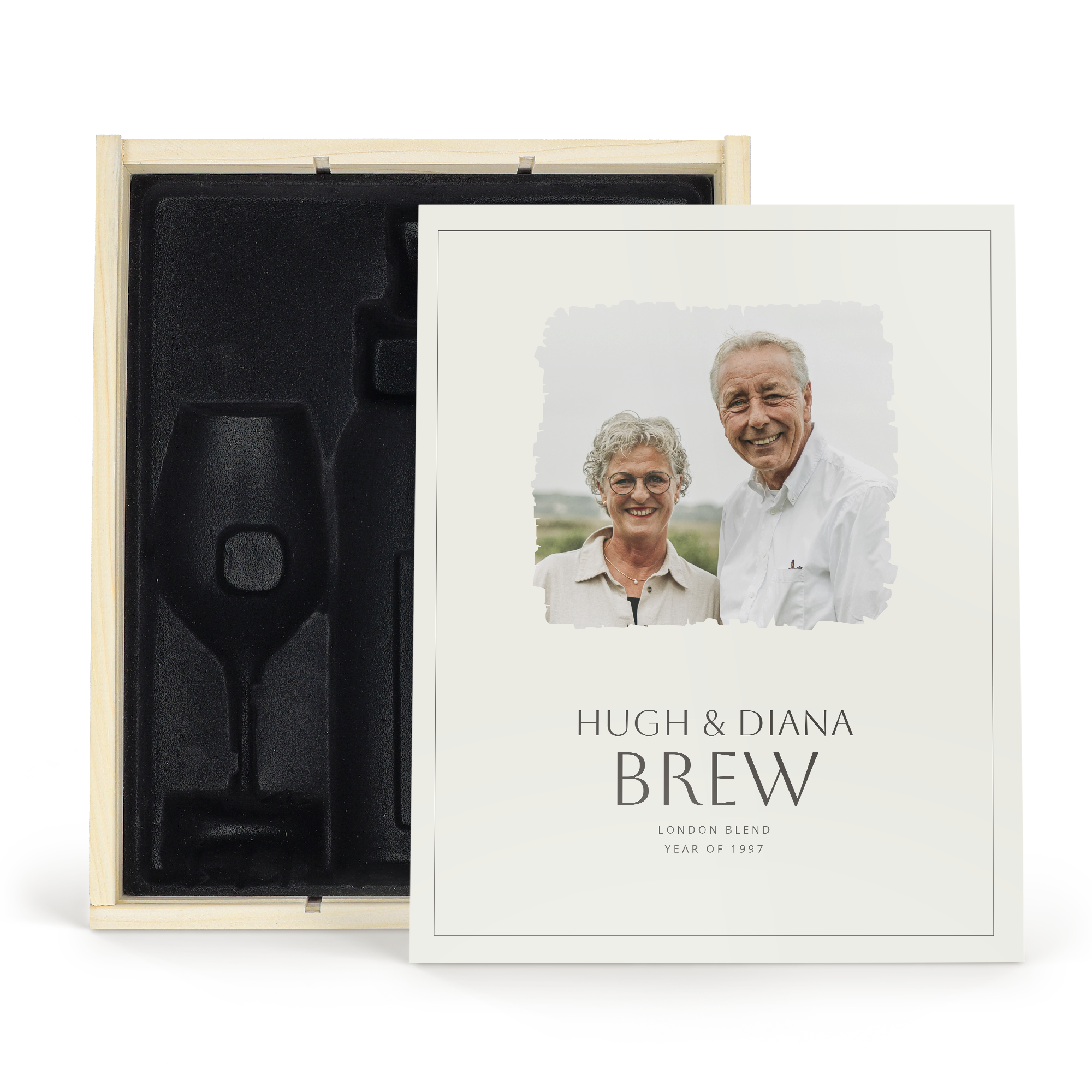 Una lussuosa custodia in legno con stampa personalizzata che mostra una foto e i nomi Hugh & Diana, spazio per una bottiglia e 2 bicchieri da vino