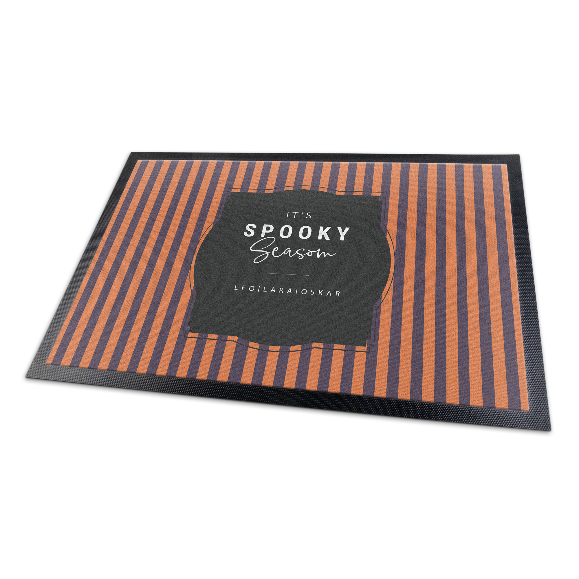 Eine einzigartige personalisierte Fußmatte mit orange-grauen Streifen und dem Text "It's spooky season LEO|LARA|OSKAR" bedruckt.