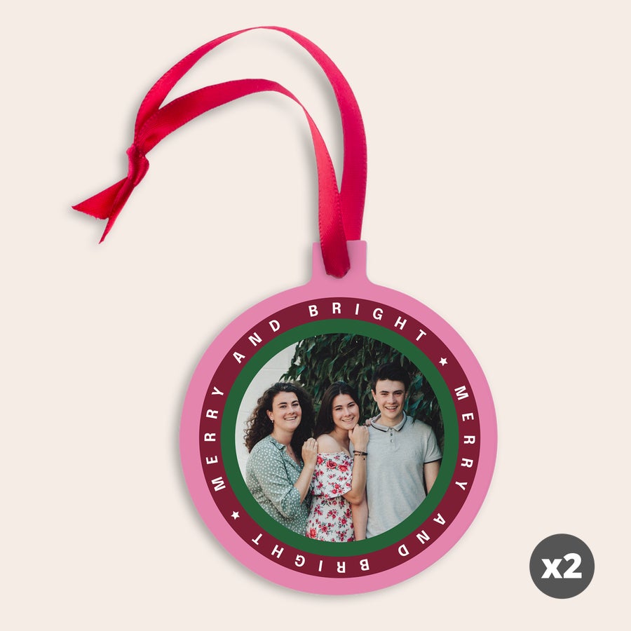 Personalised Christmas ornaments Pink aluminum Christmas ornament printed with a family photo and Merry and Bright text, with a red ribbon.