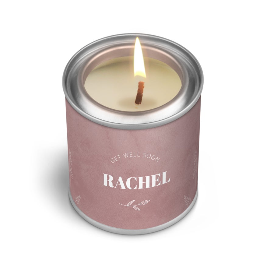 Vela personalizada com aroma de baunilha em lata rosa, com nome Rachel e a frase Get Well Soon impressos, e um pavio aceso.