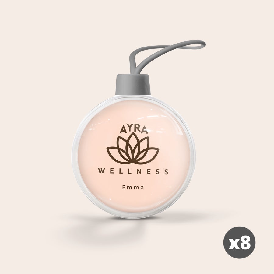 Átlátszó karácsonyi gömb Átlátszó, rózsaszín hátterű egyedi karácsonyi gömb Ayra Wellness logóval és Emma névvel nyomtatva