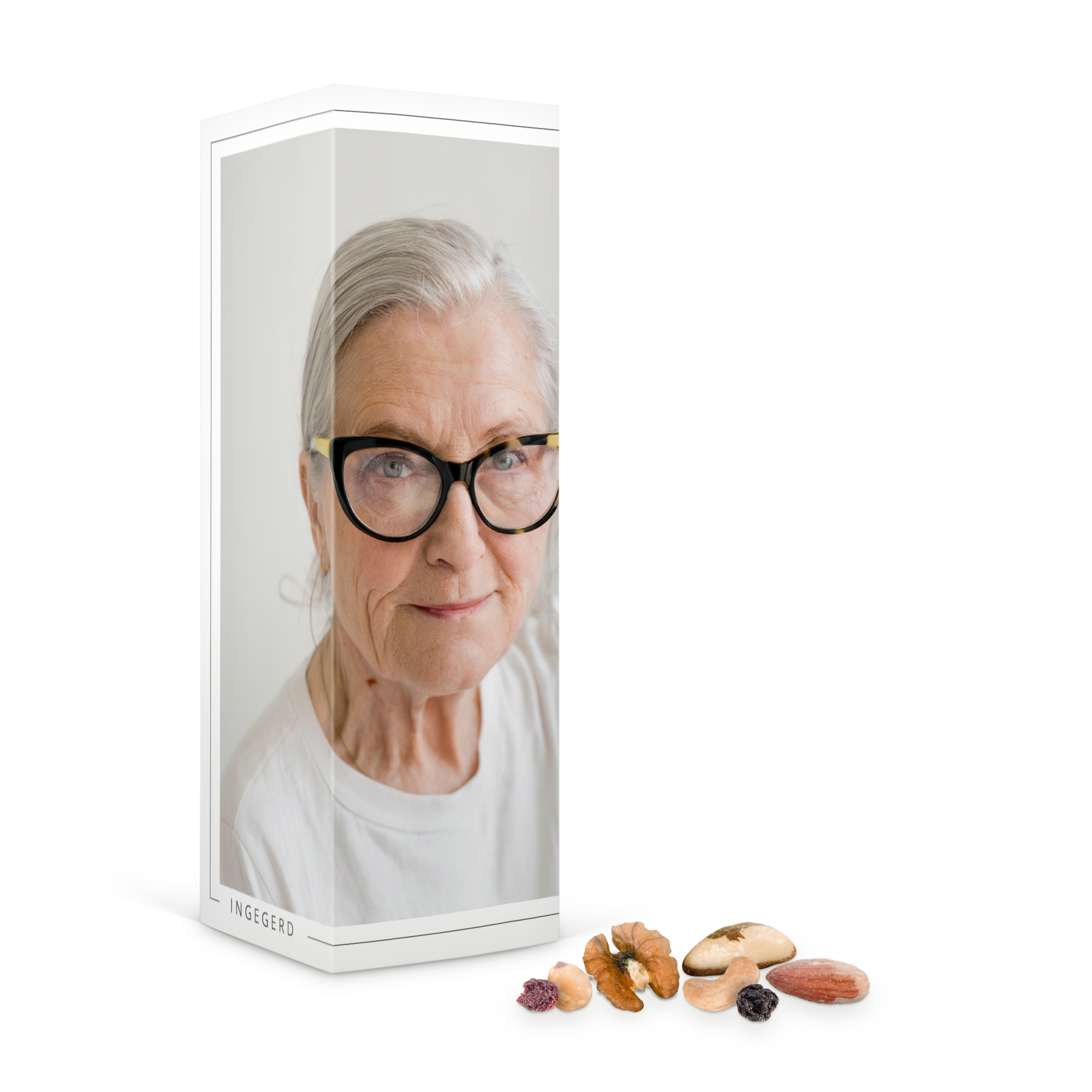 Personlig presentask med nötter, tryckt med ett foto av Ing-Gerds ansikte och utvalda nötter utspridda.