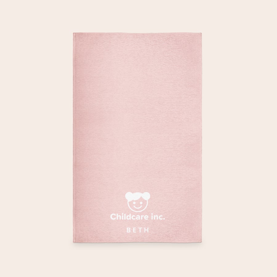 Printed Play Mat A light pink personalized play mat with a childcare logo and the name Beth printed in white