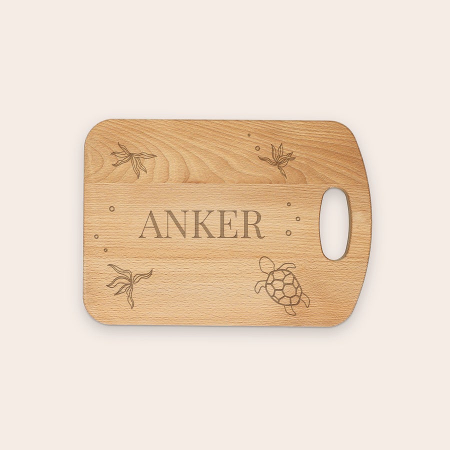 Personligt træ skærebræt Et indgraveret skærebræt af træ med navnet ANKER og hav-designs som en skildpadde