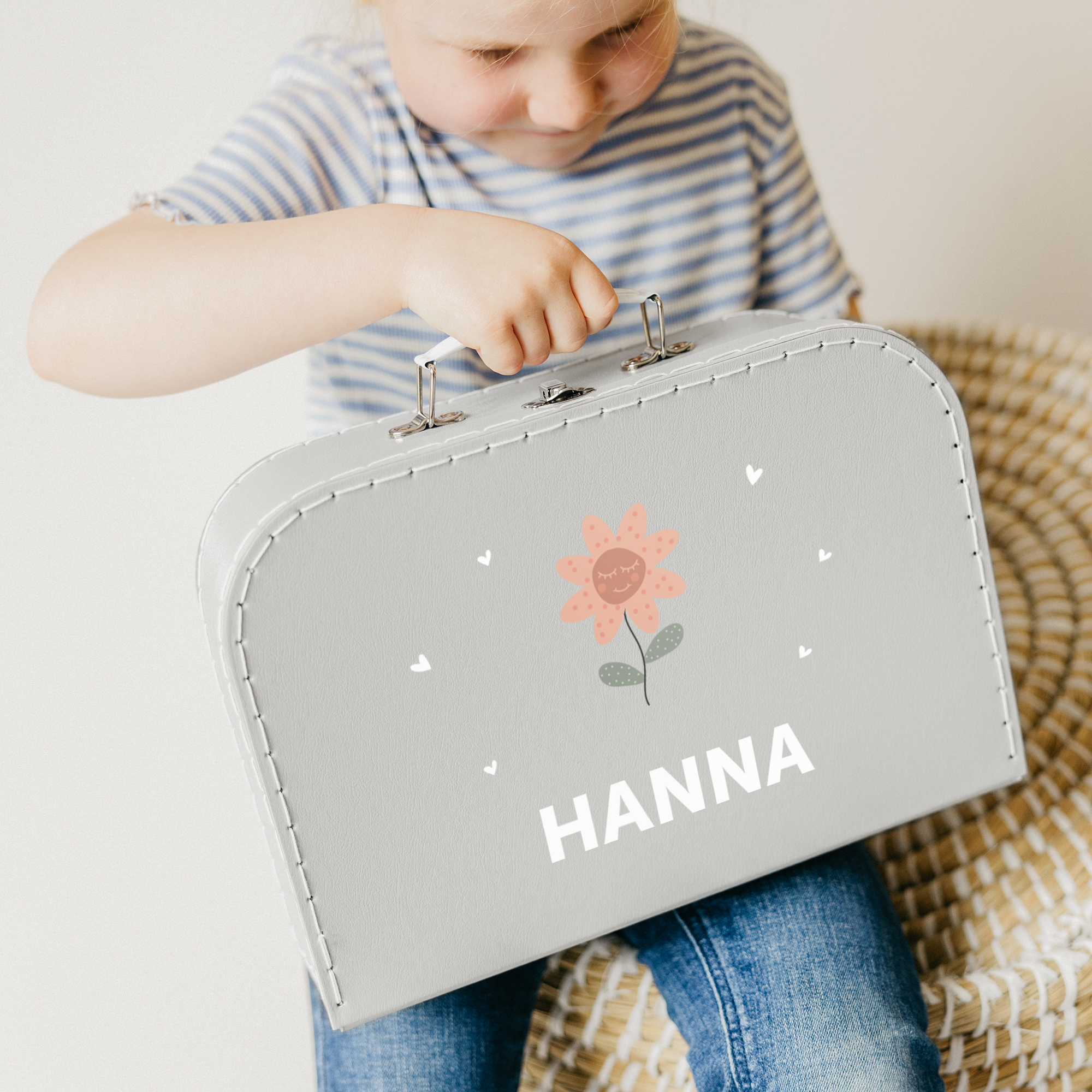 Grå lekekoffert med trykk av blomst, hjerter og navnet HANNA.