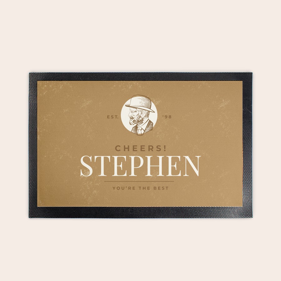 Baarimatto painatuksella Ainutlaatuinen baarimatto, jossa on kuva miehestä hatussa ja teksti "Stephen" sekä "You're the best" painettuna