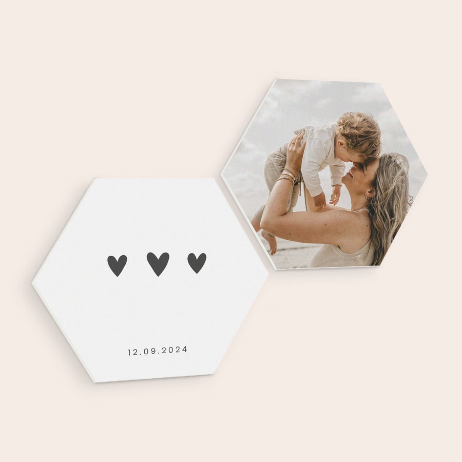 Personalised wall art panels Two hexagon forex wall art panels. One is printed with a photo of a woman holding a baby, the other with three hearts and a personalized date 12.09.2024.