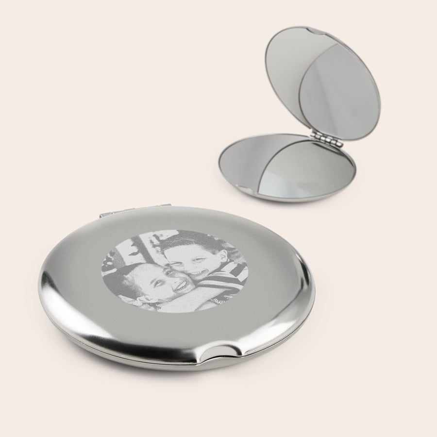 Spiegel bedrukken Zilverkleurige make-up spiegel gegraveerd met een foto van twee lachende kinderen, een open spiegel ernaast