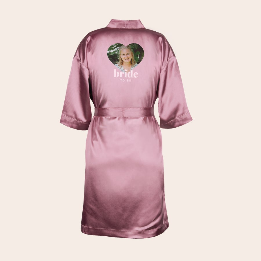 Morgenmantel personalisiert Rosa satin Kimono mit bedrucktem Herzfoto und dem Text "bride to be" auf dem Rücken, um deine Liebsten zu überraschen.