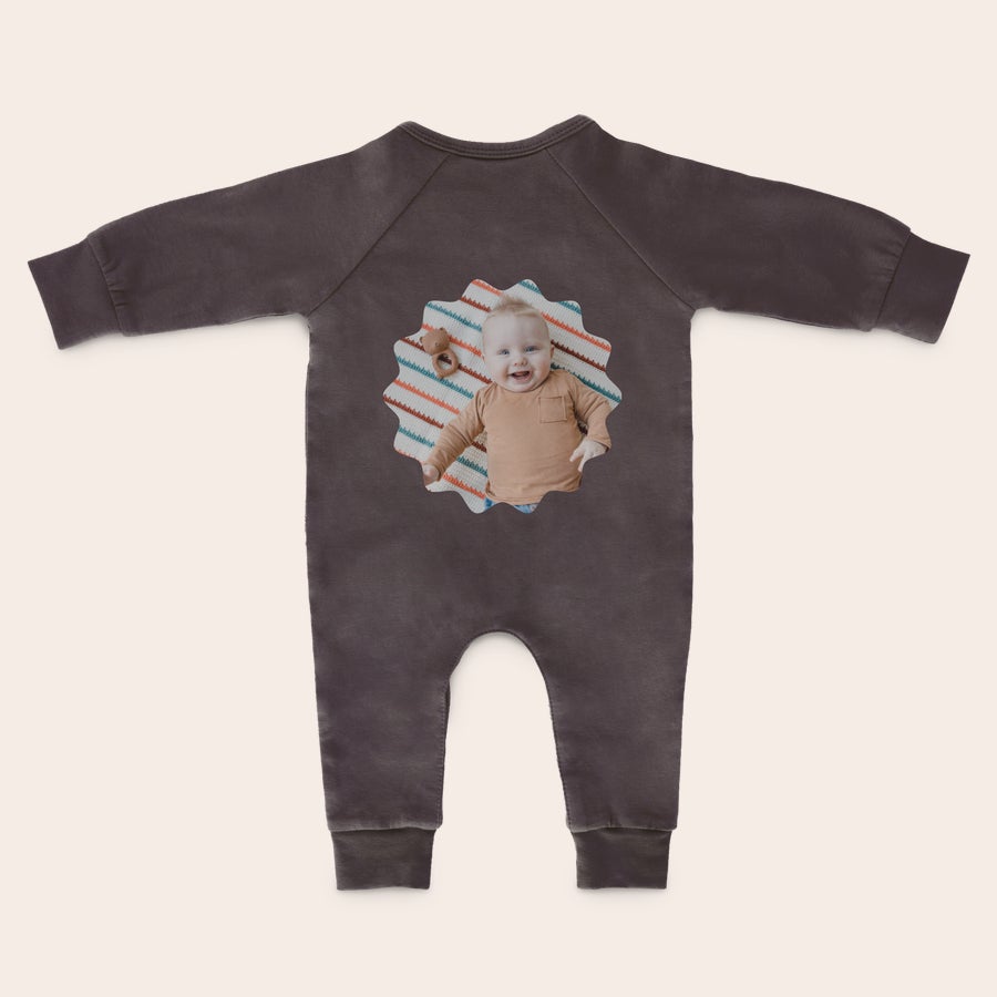 Boxpakje bedrukken Donkerbruin boxpakje met een lachende babyfoto en kleurrijk patroon bedrukt, om heerlijk te trappelen.