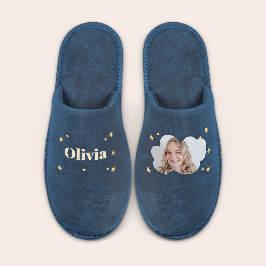 Personlige hjemmesko Et par blå personligt tilpassede hjemmesko med dit design; den ene med navnet "Olivia" og den anden med et foto af en pige, begge med printede stjerner.