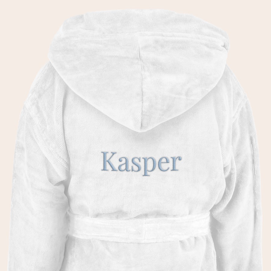 Badekåpe - barn Hvit myk barnebadekåpe med hette, brodert med navnet "Kasper" i lyseblå skrift.