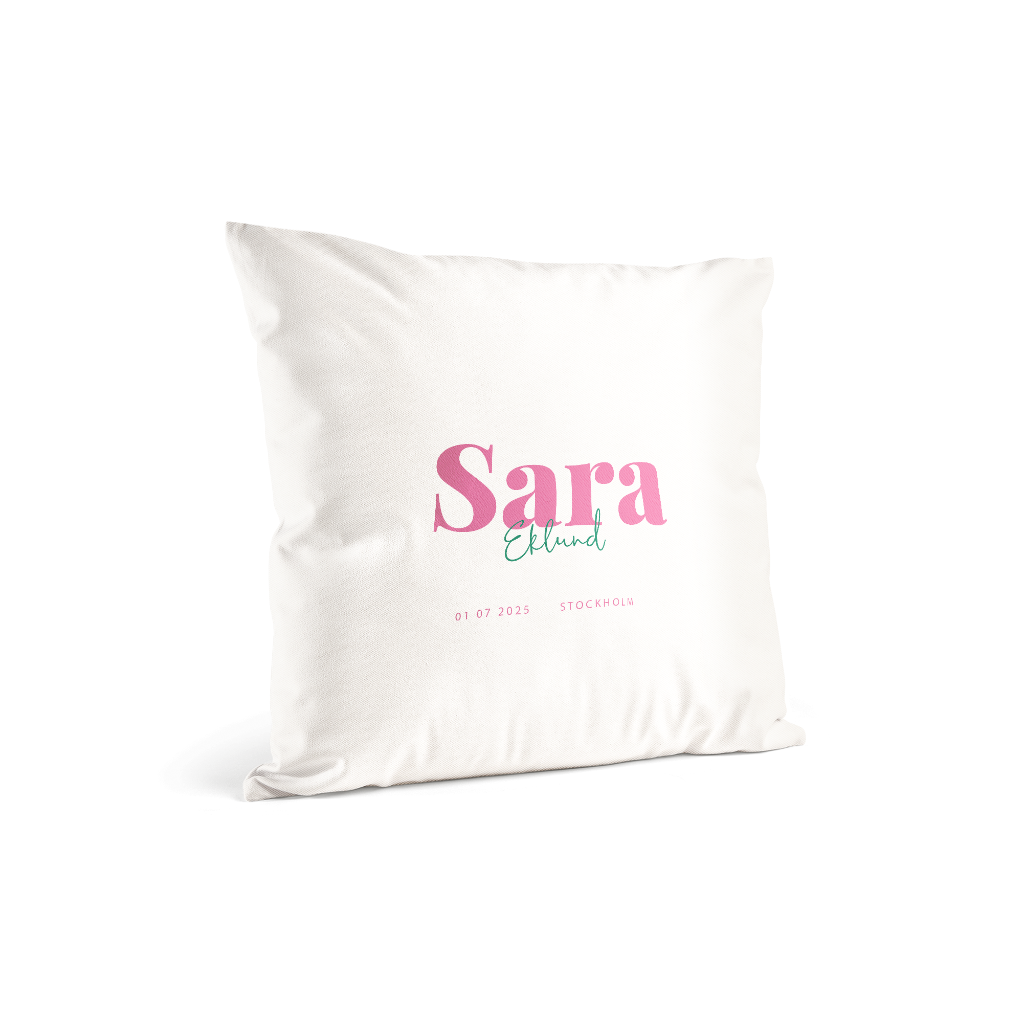 Vit kudde med namn Sara Eklund tryckt i rosa och turkos, födelsedatum och Stockholm tryckt under.