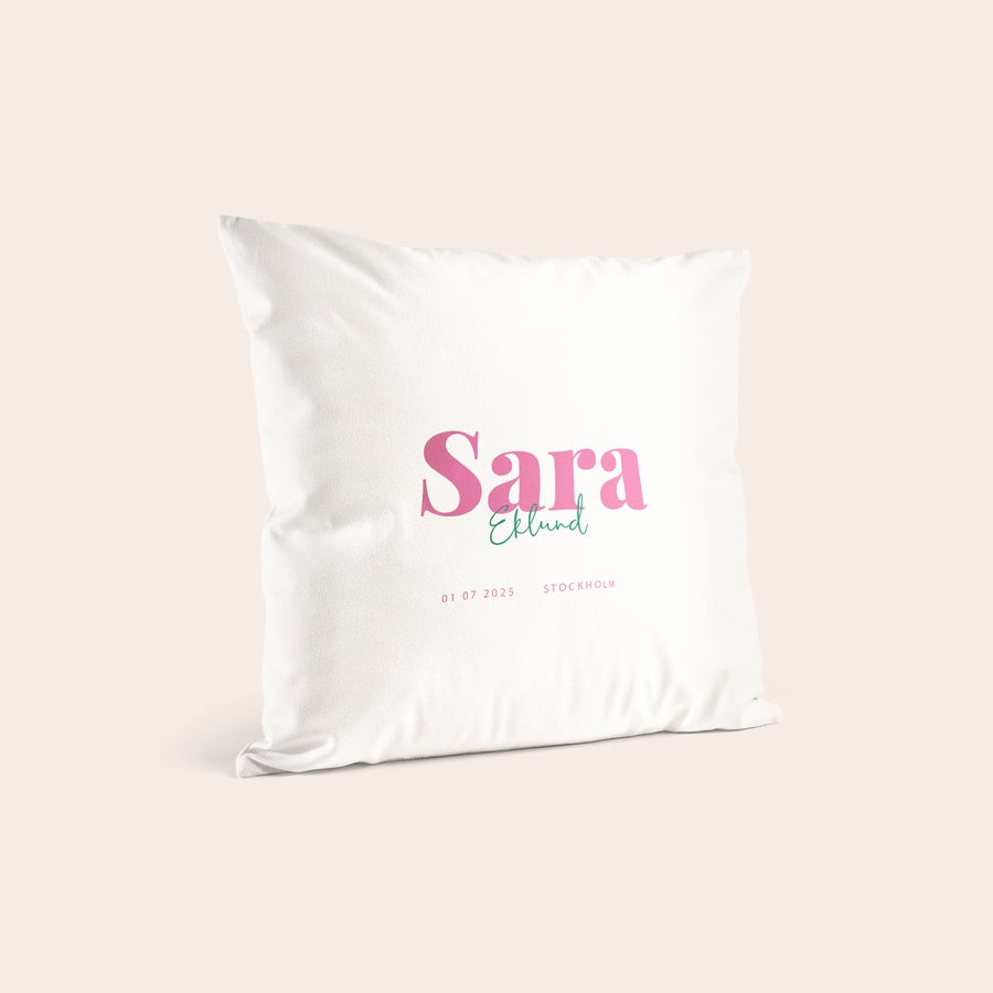 Födelsekudde med tryck - Vit Vit kudde med namn Sara Eklund tryckt i rosa och turkos, födelsedatum och Stockholm tryckt under.