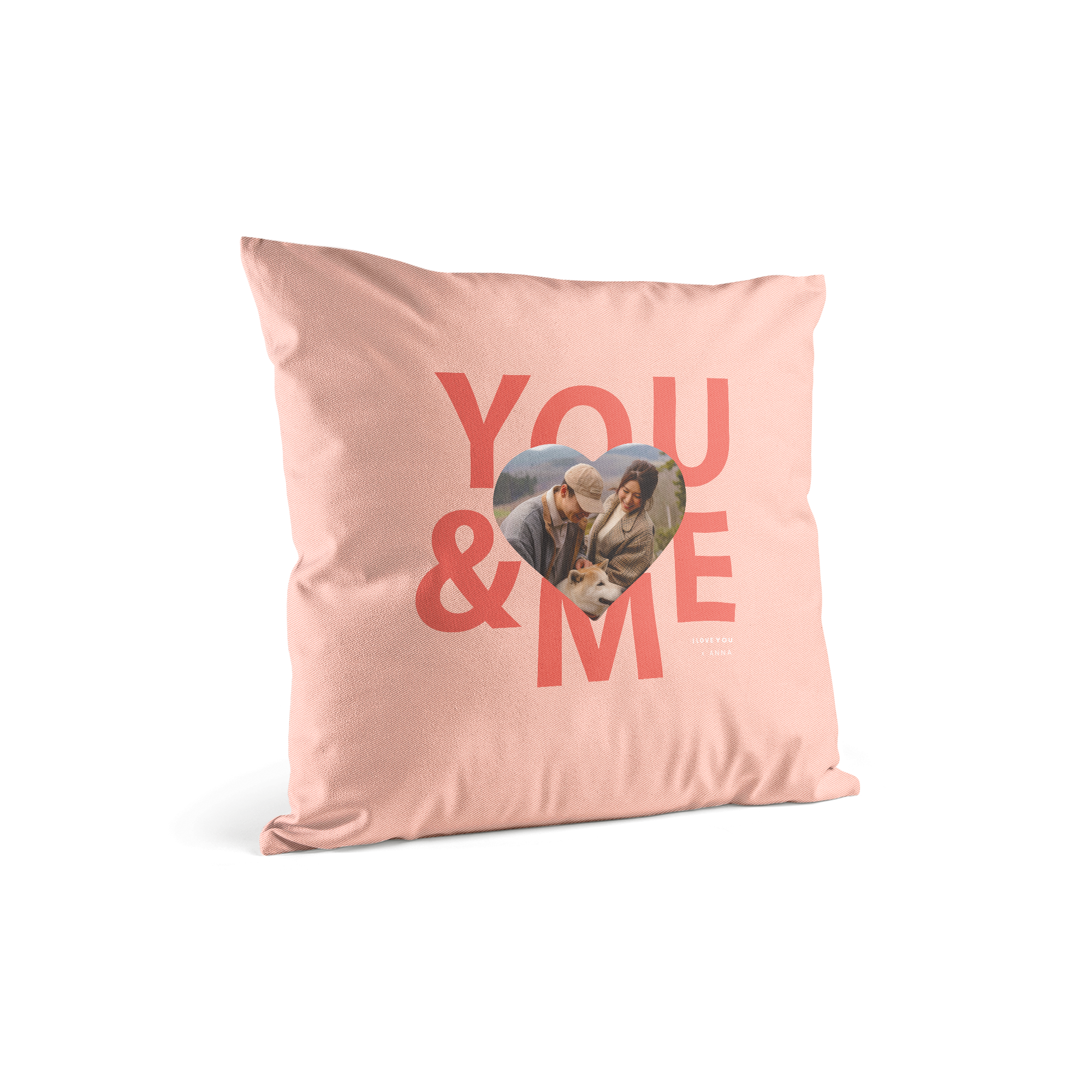 Púdrovo ružový vankúš s potlačou veľkého nápisu You & Me a prispôsobenou fotografiou páru v srdci s textom I love you Anna.
