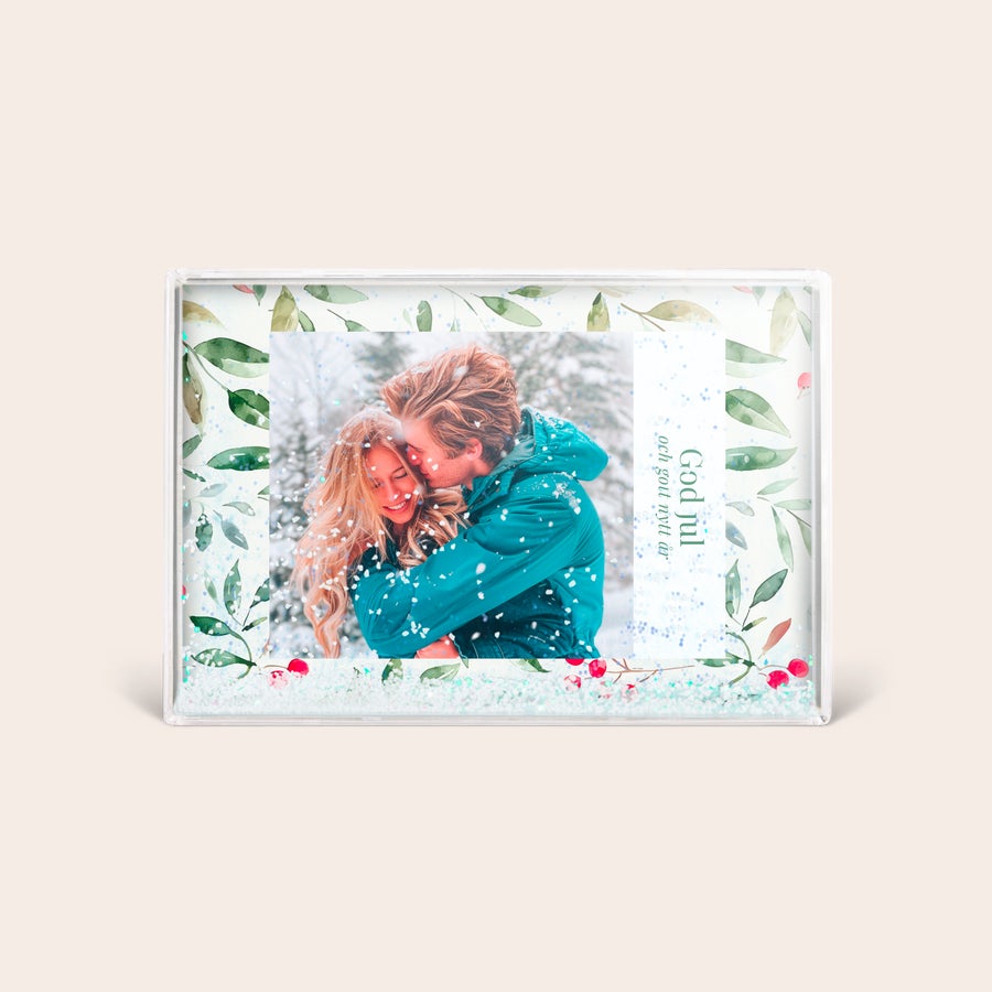 Personlig snöklot - rektangel Personlig fotoram med snö, tryckt med egna foton och God Jul och gott nytt år-text, omgiven av gröna blad och röda bär.
