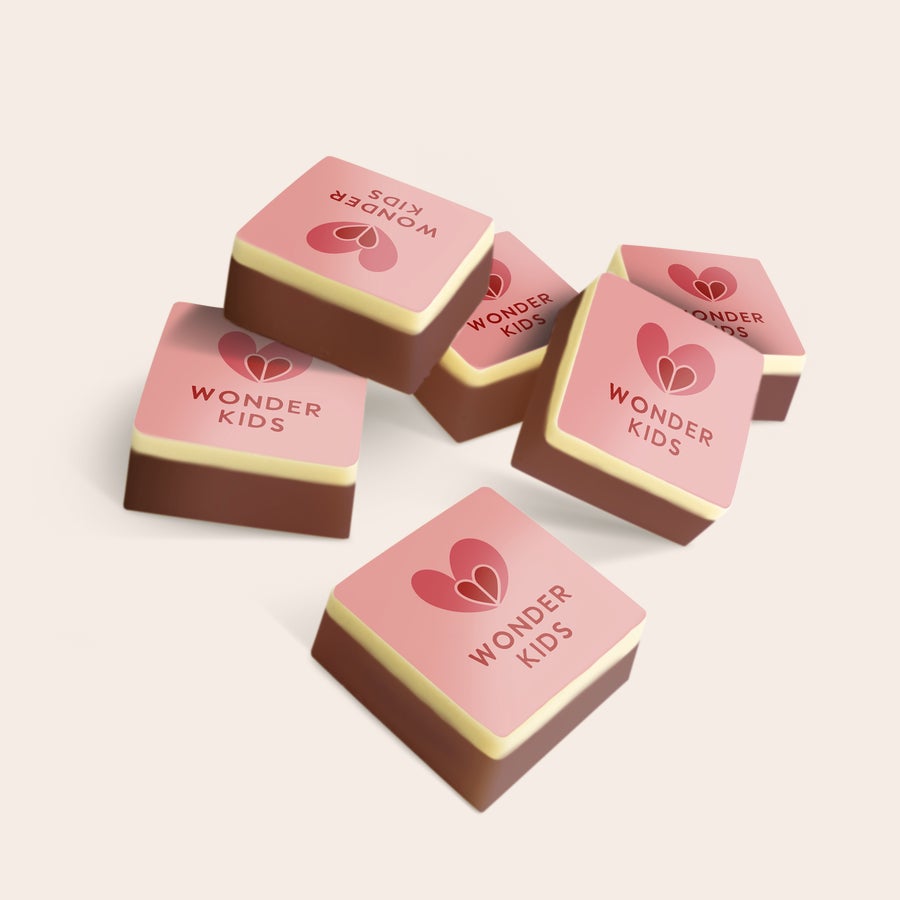 Bombons com foto Chocolates personalizados de leite e branco com logo Wonder Kids e corações vermelhos impressos.