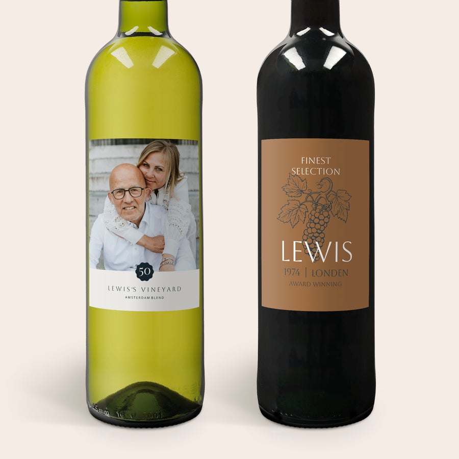 Maison de la Surprise Duas garrafas de vinho, Sauvignon Blanc e Merlot, com rótulos personalizados com foto e texto.