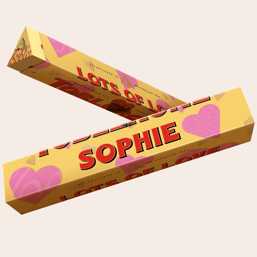 Toblerone con diseños románticos Barra de Toblerone personalizada con el nombre "SOPHIE" impreso en la envoltura dorada, con diseños de corazones rosas.