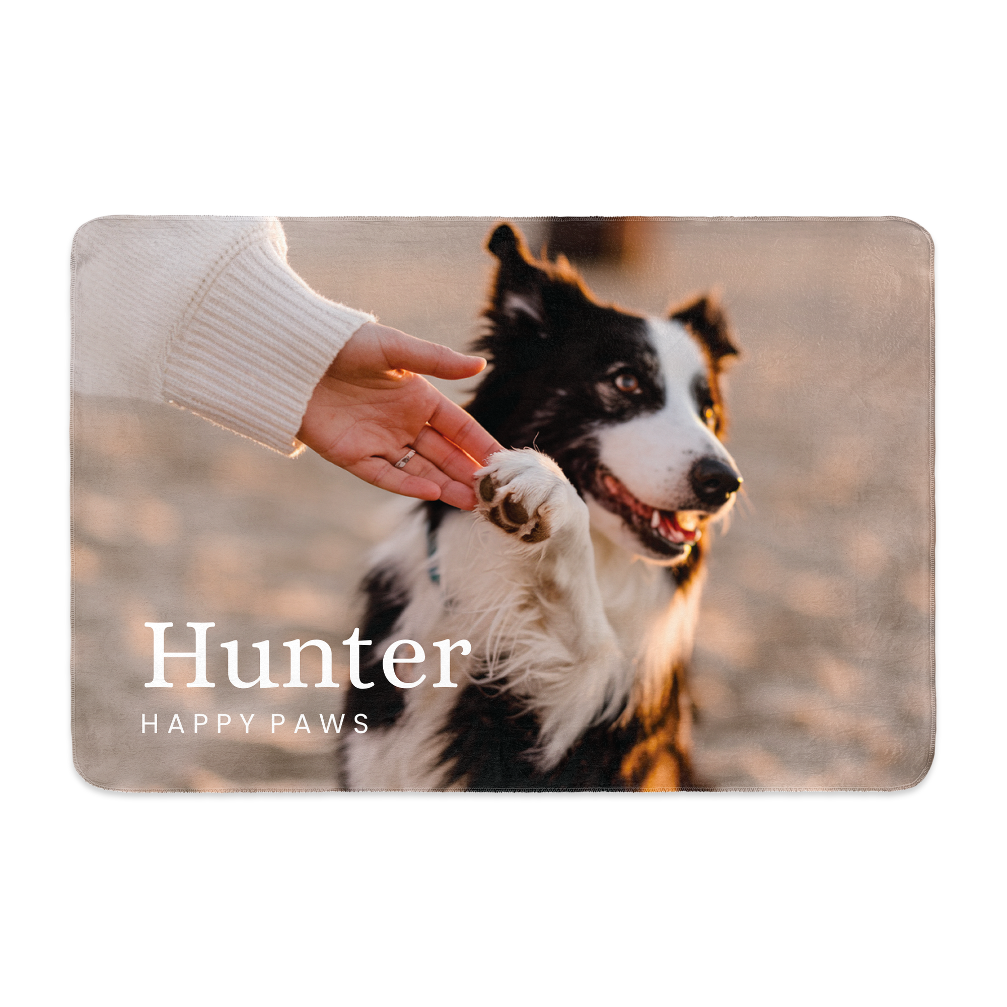 Manta de felpa impresa con una foto de un perro blanco y negro, el nombre Hunter y Happy Paws, y una mano acariciando su pata.