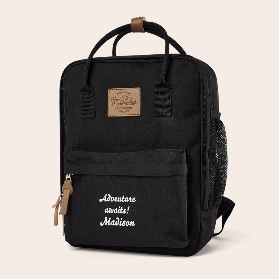 Zaino per Bambini con Nome Zainetto per bambini personalizzato nero con scritta bianca "Adventure awaits! Madison" stampata sulla tasca frontale