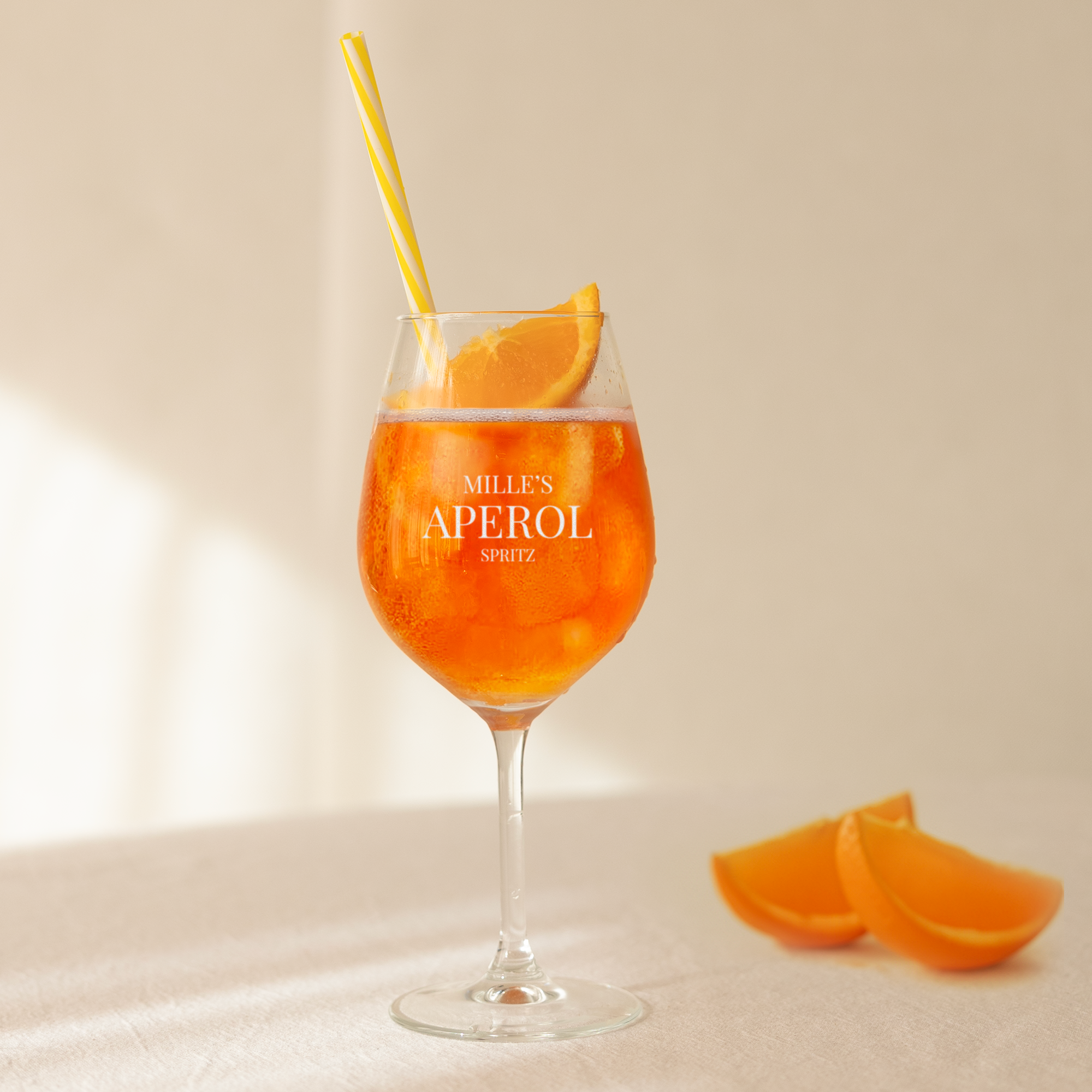 Personlig Aperol Spritz glass med gravert teksten Mille's Aperol Spritz, appelsinskive og sugerør.