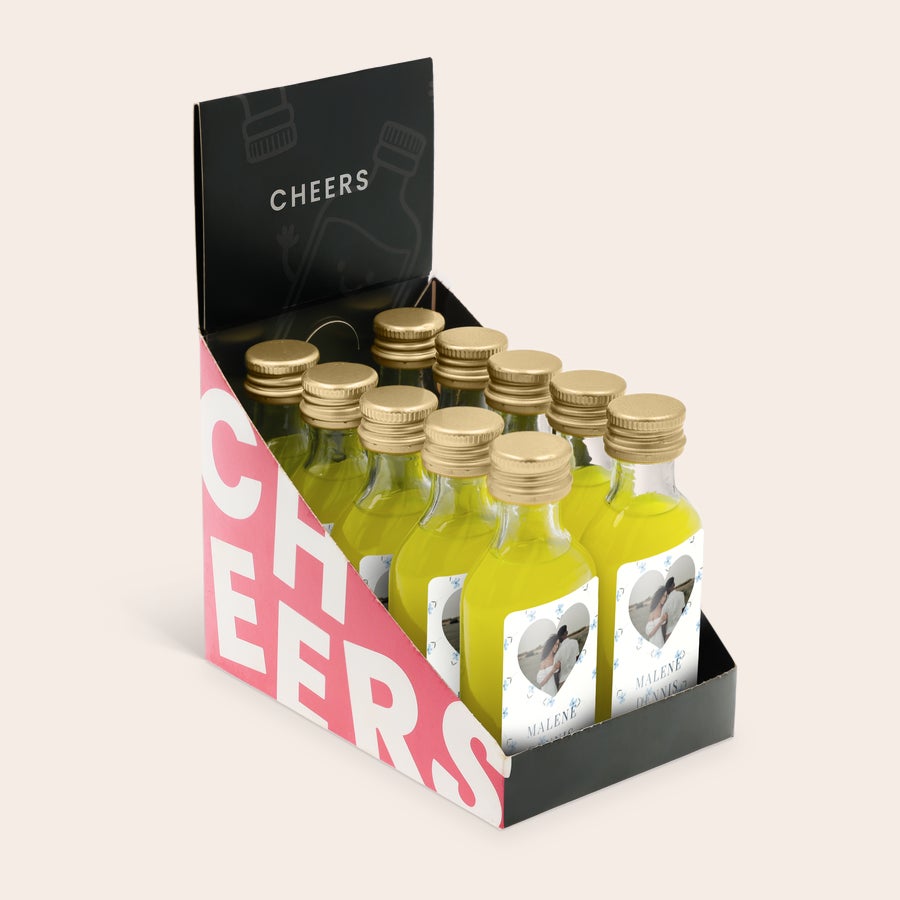 Personlige mini-alkoholflasker Skab en unik Mini Limoncello-kollektion med 10 personlige flasker, trykt med et billede af et par og navnene Malene og Dennis.