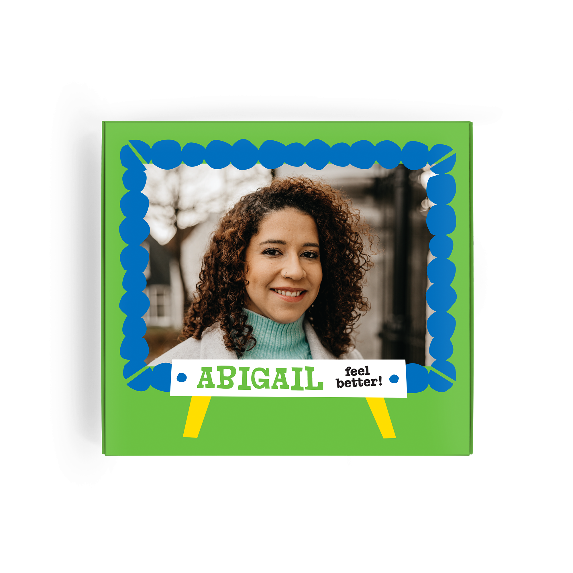 Caja verde de Tony's Chocolonely, impresa con la foto de una mujer sonriendo, el nombre Abigail y el mensaje "feel better!".