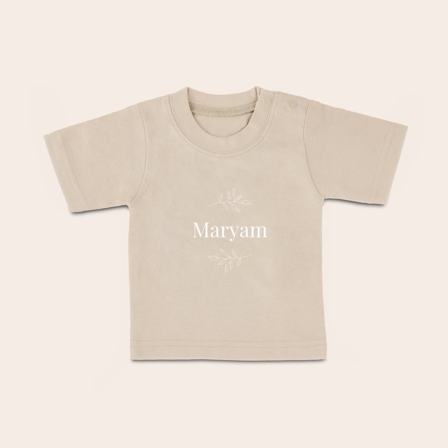 Baby shirt bedrukken Een beige baby shirt met naam "Maryam" en takjes bedrukt, perfect voor jouw kleintje.