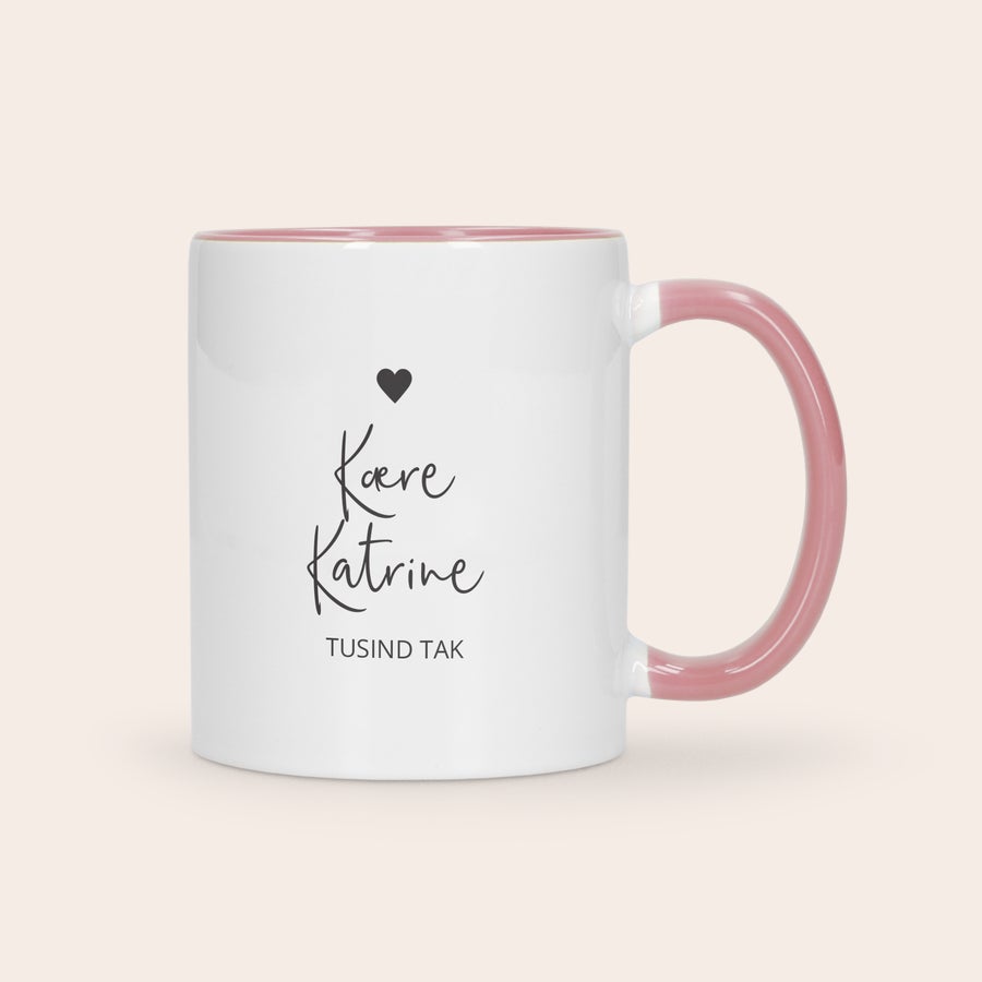 Farverig krus Hvidt farverigt krus med lyserød inderside og hank, med trykt billede af et sort hjerte og teksten Kære Katrine TUSIND TAK. Giv et flot farverigt krus med billede som gave.