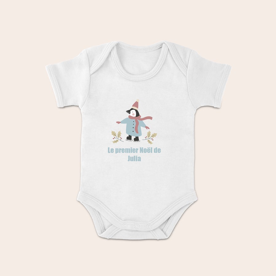 Body mon premier Noël personnalisé Dors-bien blanc imprimé avec un pingouin patineur et le texte Le premier Noël de Julia.